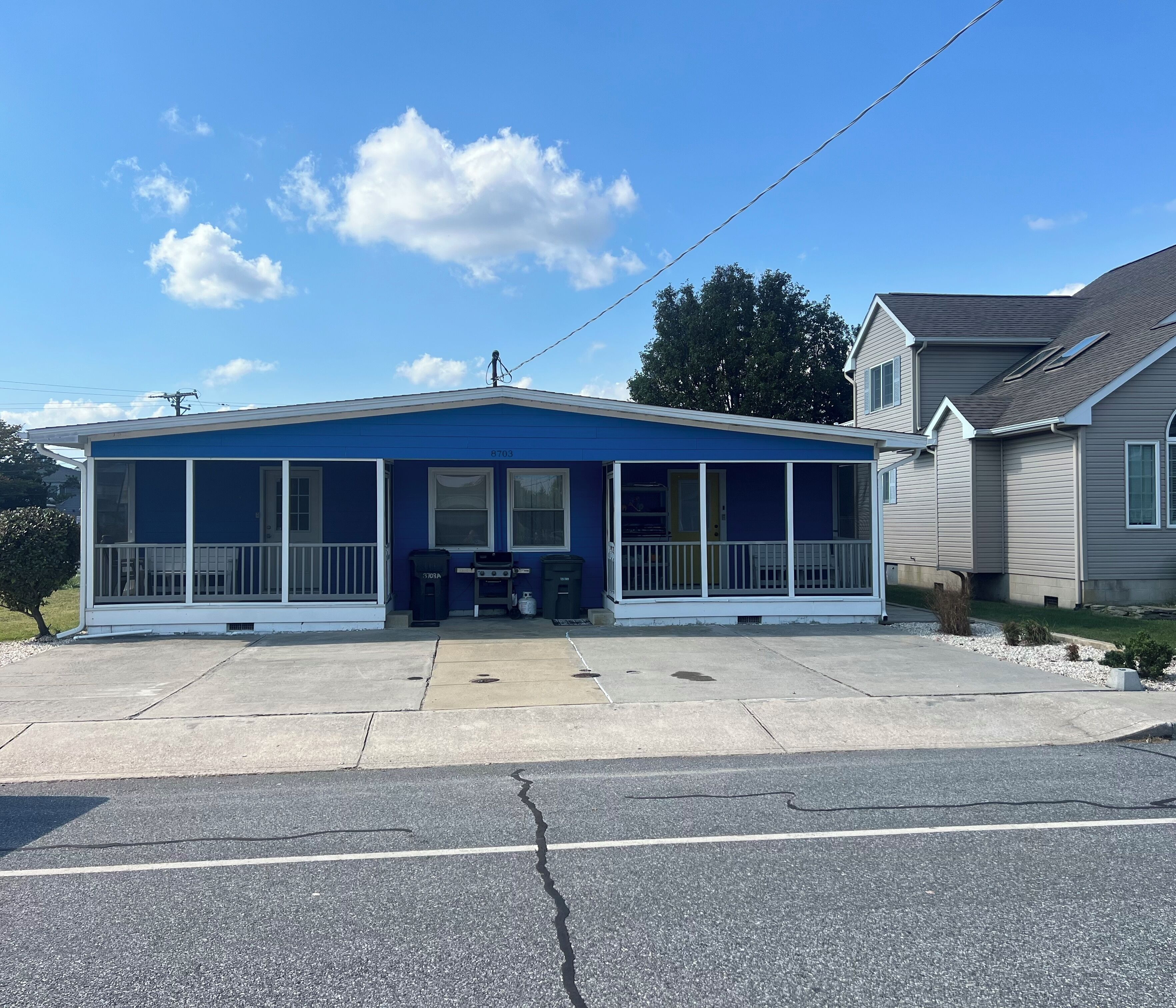 A single-story house with a blue exterior and a covered porch.