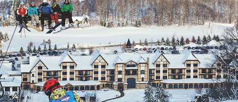 A ski resort with a large lodge featuring a symmetrical facade, multiple windows, and a central entrance.