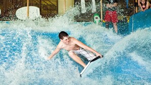 A person surfing on a wave in a pool. - Boyne Mountain on Resort Condo, close to Lifts, Lodge, Waterpark, all amenities (Boyne Falls)