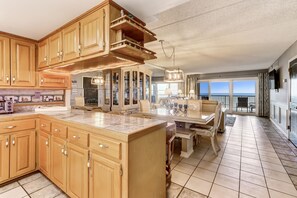 Una cocina amplia con armarios de madera, una isla grande y un comedor con vistas.