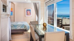 Una habitación con cama, una mesa de comedor y vistas a la playa.