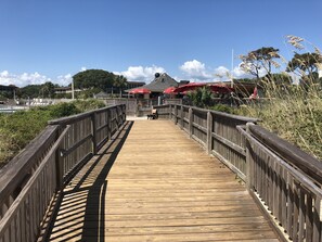Stroll along the waterfront boardwalk to a charming eatery with a red roof.