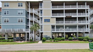 A multi-story building with balconies, a sign for Ocean Boulevard Villas, and a street in front. - Ocean Blvd Luxury Villas 205, Pool & Hot Tub (NORTH MYRTLE BEACH)