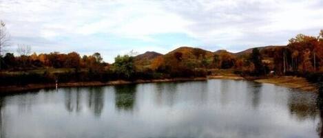 A calm lake with reflections of trees and hills.