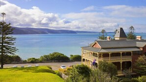A coastal property with a large bay view, a prominent building with a balcony, and a clear sky. - Lorne Penthouse - water views (Lorne)