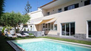 A swimming pool with lounge chairs and a patio area. - Lovely House in Lisbon coast For 8 guests (São Domingos de Rana)