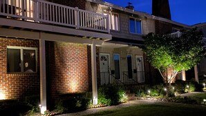 Une maison à deux étages avec un balcon et une façade en briques.