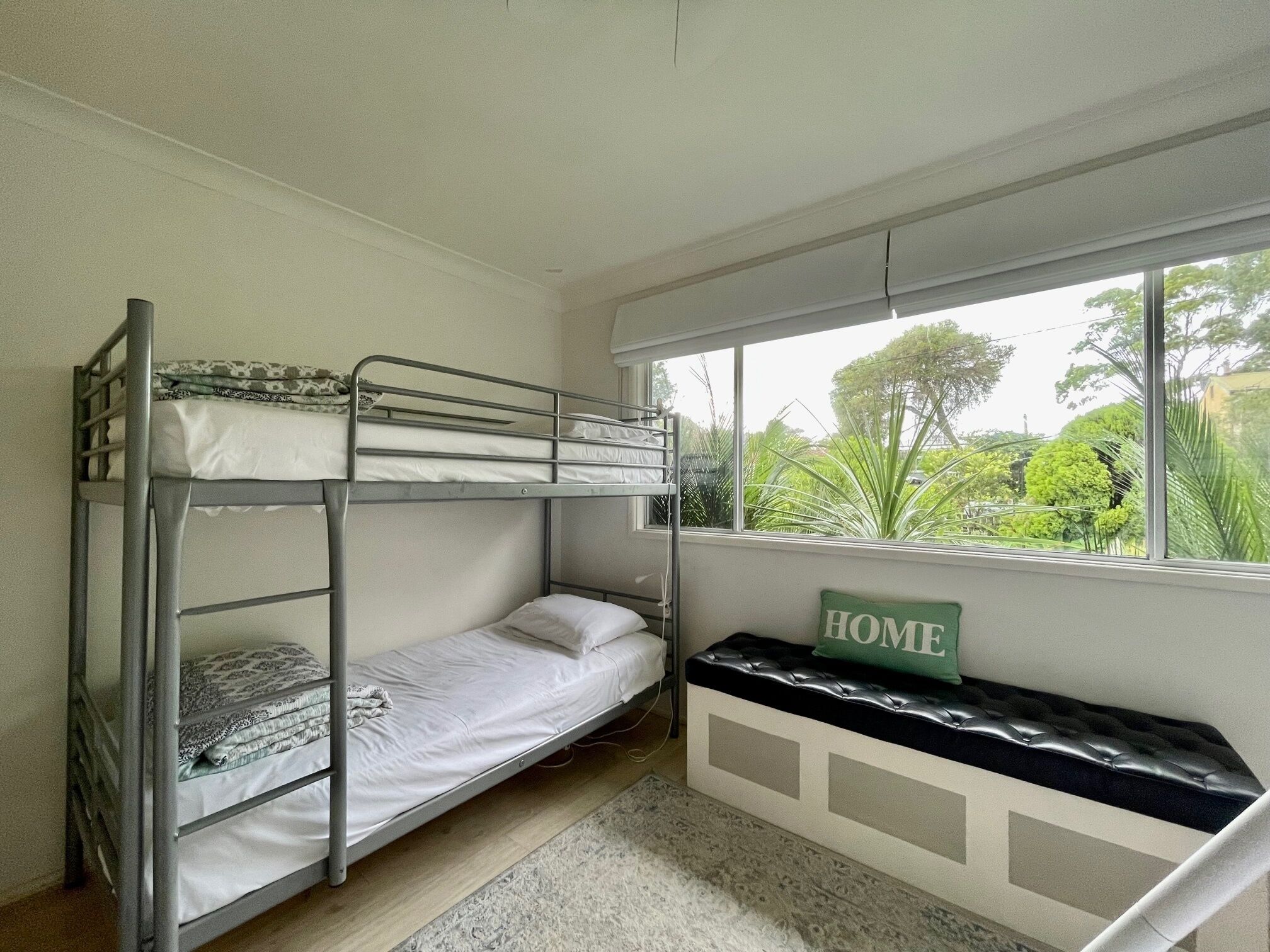 Habitación con literas, una ventana y un letrero que dice 'HOME'.