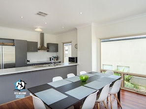 A modern kitchen with grey cabinets, a stainless steel refrigerator, and a microwave.