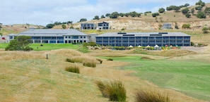 A golf course with a clubhouse and buildings in the background. - 24/45 St. Andrews Blvd, Normanville - Contemporary Golf Course Frontage 3BR (Normanville)