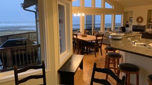 A spacious kitchen with a large island, a dining area with a view of the beach, and a cozy seating area with a fireplace. - Oceanfront Beach House-Nestled on the N. Beach of the Washington Coast (Moclips)