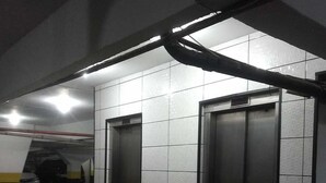 Ein Korridor mit zwei Aufzügen und einer Kachelwand.