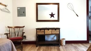 A room with a wooden chair, a framed star decoration, a woven basket, and a whisk on the wall. - Serene Country Cabins 2 In the heart of Vermont (Hyde Park)