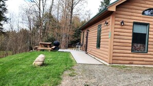 A log cabin with a porch, a picnic table, and a stone. - Serene Country Cabins 2 In the heart of Vermont (Hyde Park)