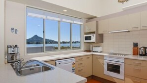 A modern kitchen with a large window, a microwave, a toaster, and a dishwasher. - Perfect for the golfer or the family beach holiday (Tairua)