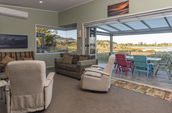 A spacious living area with a large glass door leading to a balcony with a scenic view.