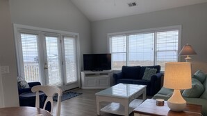 A living room with a TV, two sofas, a coffee table, and a lamp. - Condo with AMAZING Ocean View! Labor Day Weekend is available and discounted ! (Ocean Isle Beach)