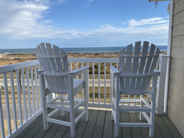 Two white Adirondack chairs on a wooden deck with a view of the beach and ocean. - Condo with AMAZING Ocean View! Labor Day Weekend is available and discounted ! (Ocean Isle Beach)