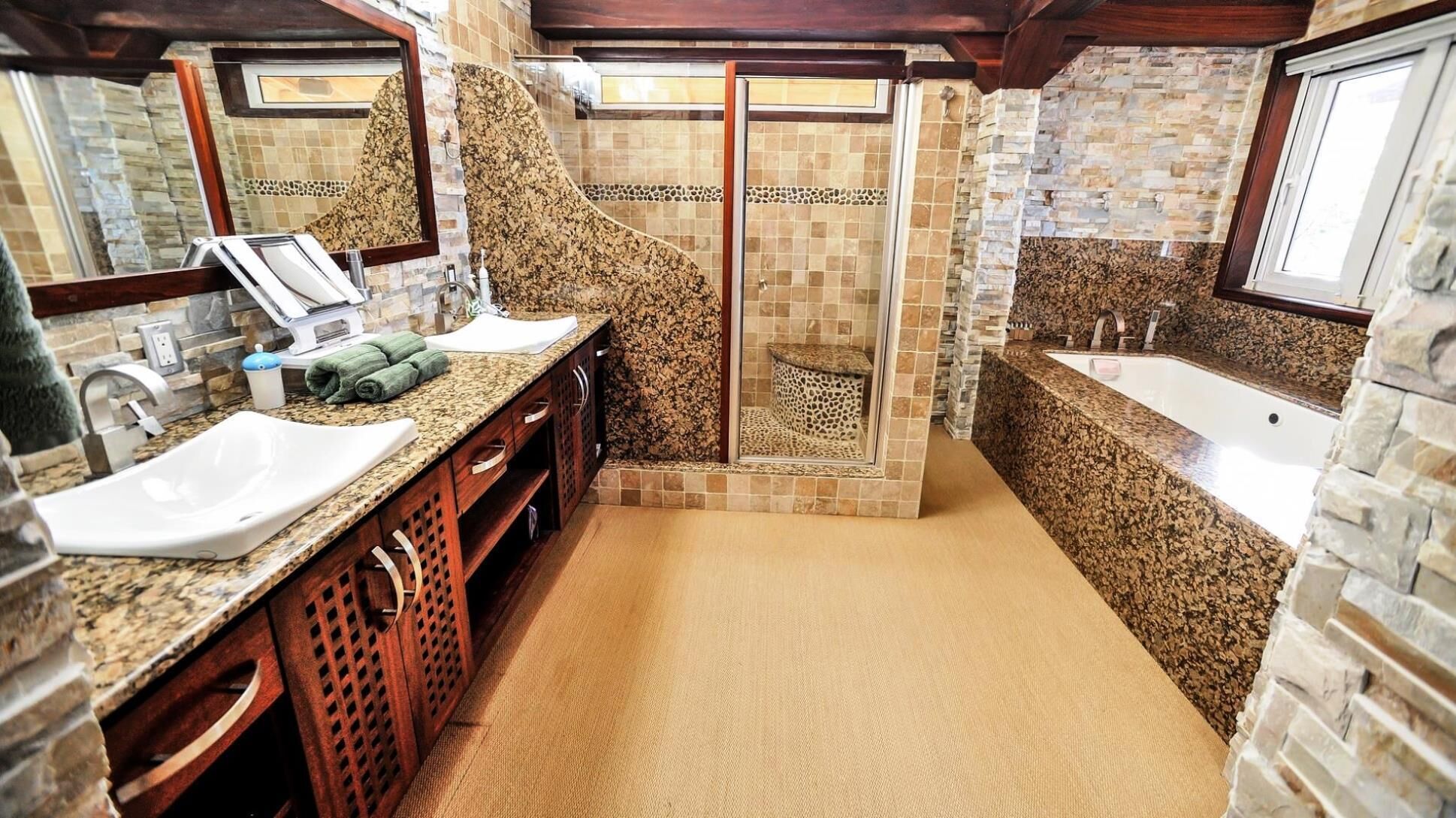 Un baño con dos lavamanos, ducha y bañera.
