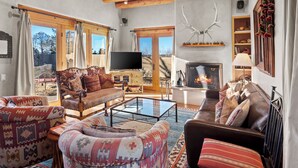 A cozy living room with a fireplace, comfortable seating, and a television. - Casa Don Miguel | Stylish Retreat (Santa Fe)