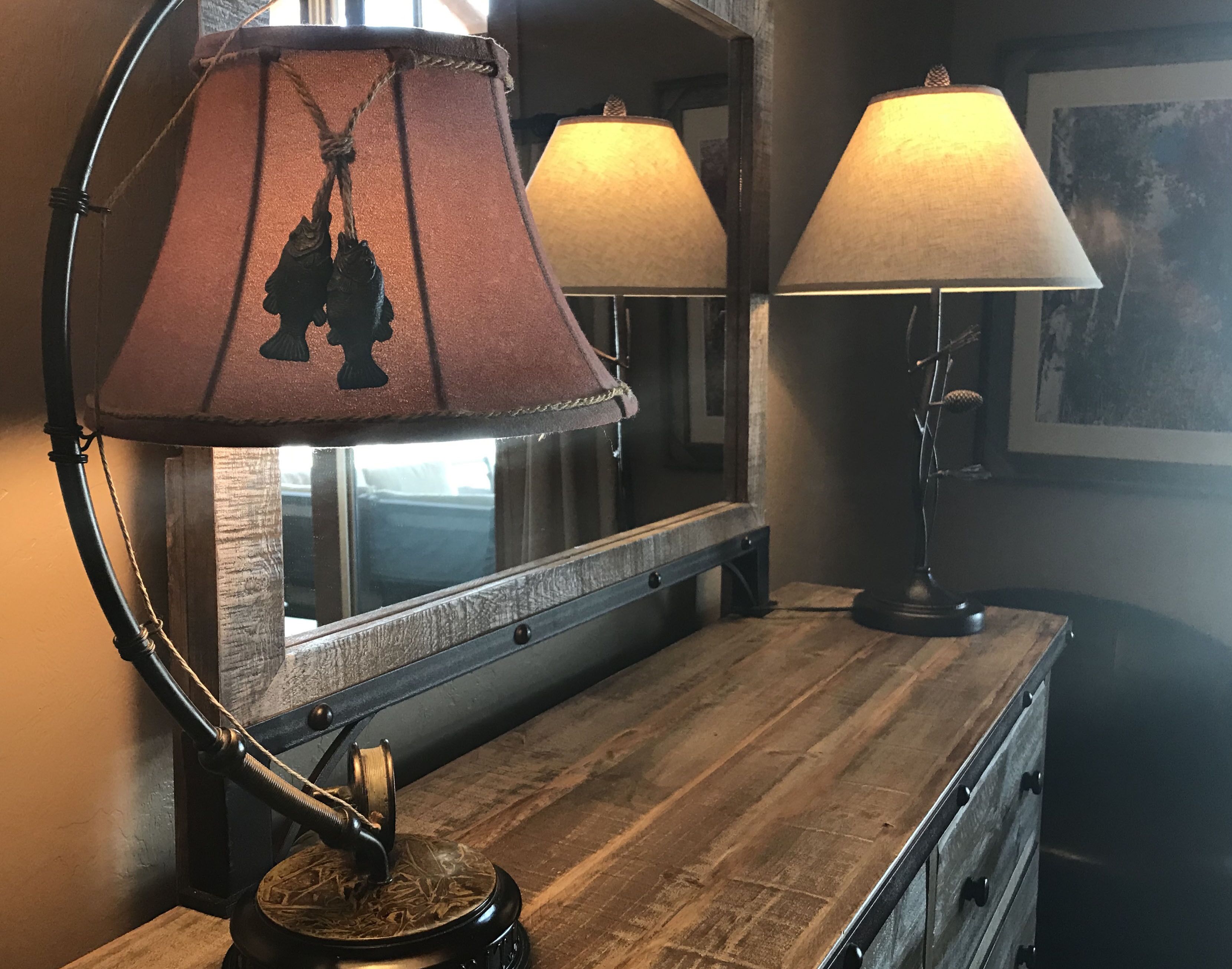 Une commode en bois avec un miroir et deux lampes.