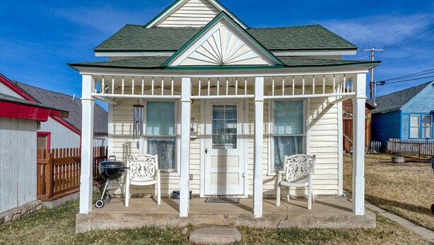 Ein eingeschossiges Haus mit Veranda, Eingangstür und Garagentor.