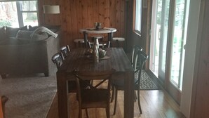 Un coin repas en bois avec une table et des chaises, un canapé et une lampe.