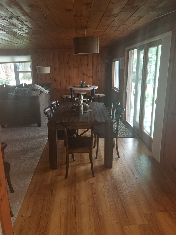 Un comedor de madera con una mesa, sillas, un sofá y una lámpara.