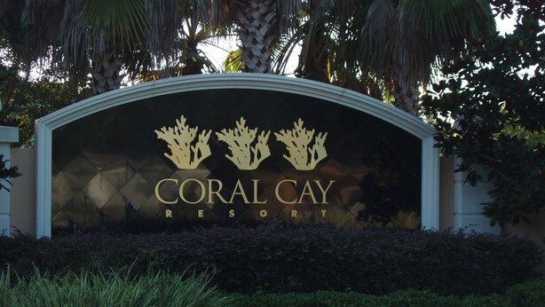 Schild für das Coral Cay Resort mit dekorativem Korallenmotiv.