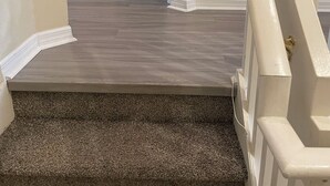 Eine Treppe mit Teppich und einem weißen Geländer.