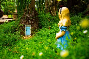 Step into a whimsical garden setting, complete with a charming treehouse door and lush greenery.