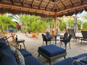 An outdoor seating area with wicker furniture and a thatched roof. - Vista Tortuga - VILLA CORAL Heated Pool by the BEACH (Todos Santos)