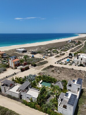Une zone résidentielle côtière avec des maisons, une plage et un ciel dégagé.