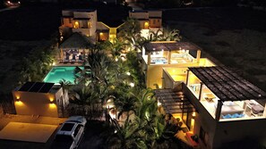 Un complexe hôtelier doté d’une piscine, de plusieurs chambres et d’une voiture garée à l’extérieur.
