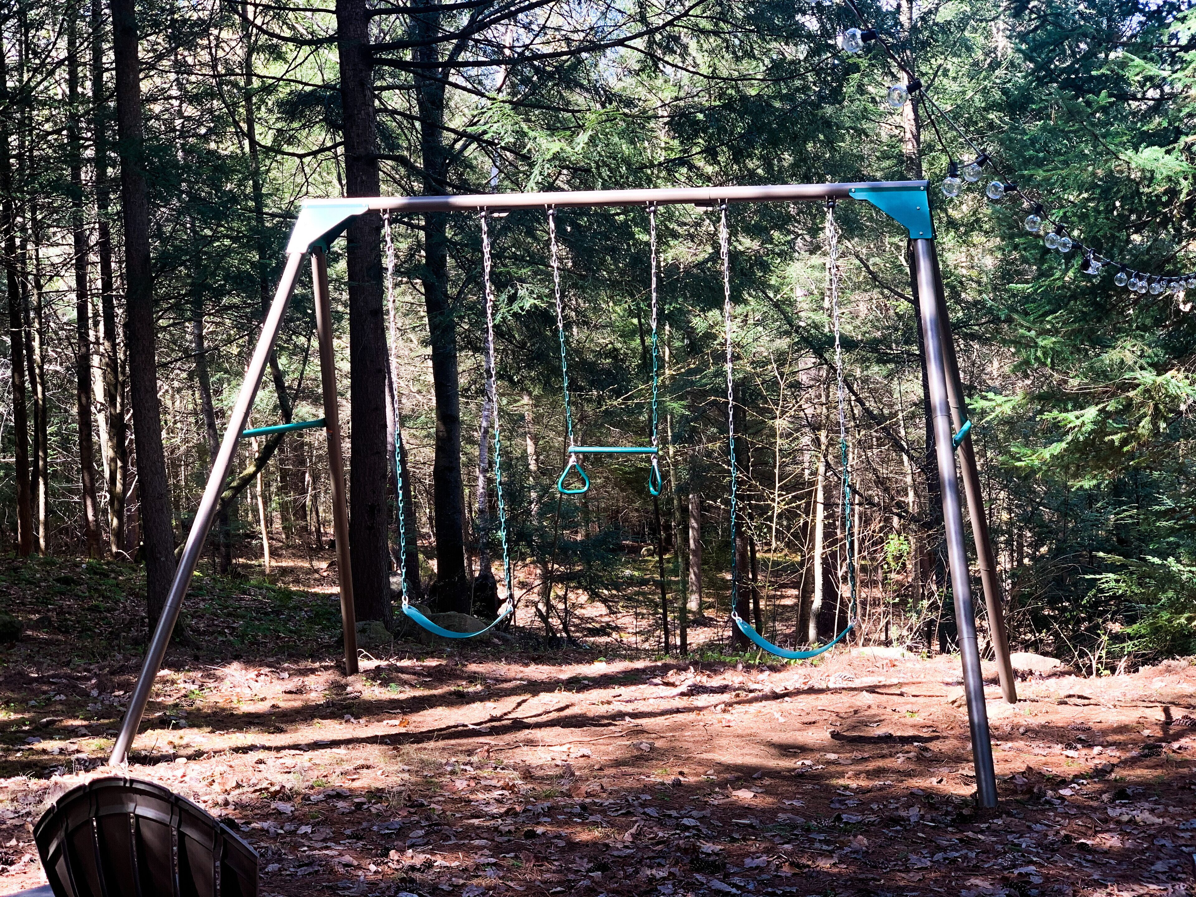 A swing set in a wooded area.