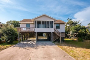 A two-story house with a covered entryway, a balcony on the first floor, and a small deck on the second floor. - 424 Community Pool, Elevator, & Screened-In Deck (Nags Head)