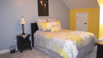 A bedroom with a bed, nightstands, a lamp, and a door.