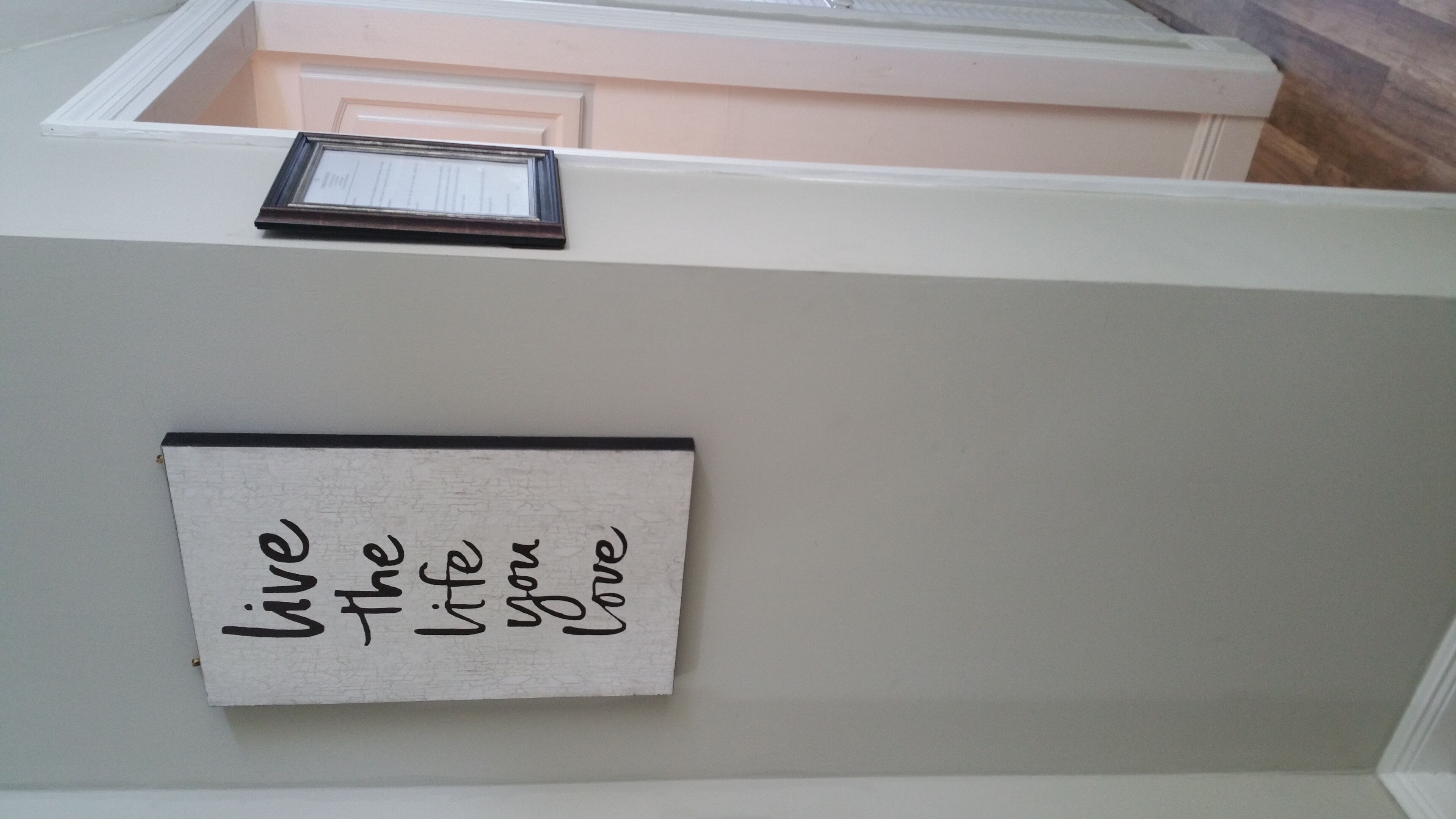 A wall with a sign that reads "live the life you love."