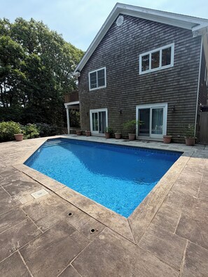 Ein Wohnhaus mit Swimmingpool, einem zweigeschossigen Haus und einem eingezäunten Garten.