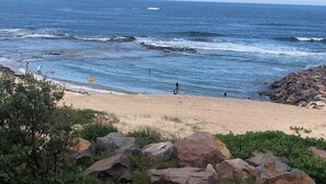 Une plage avec des affleurements rocheux et des vagues.