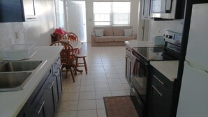 Una cocina con comedor, sofá y refrigerador.