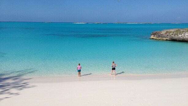 Una playa con agua turquesa cristalina y arena blanca.