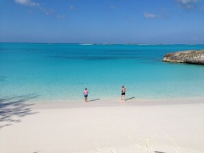 A beach with clear turquoise water and white sand.