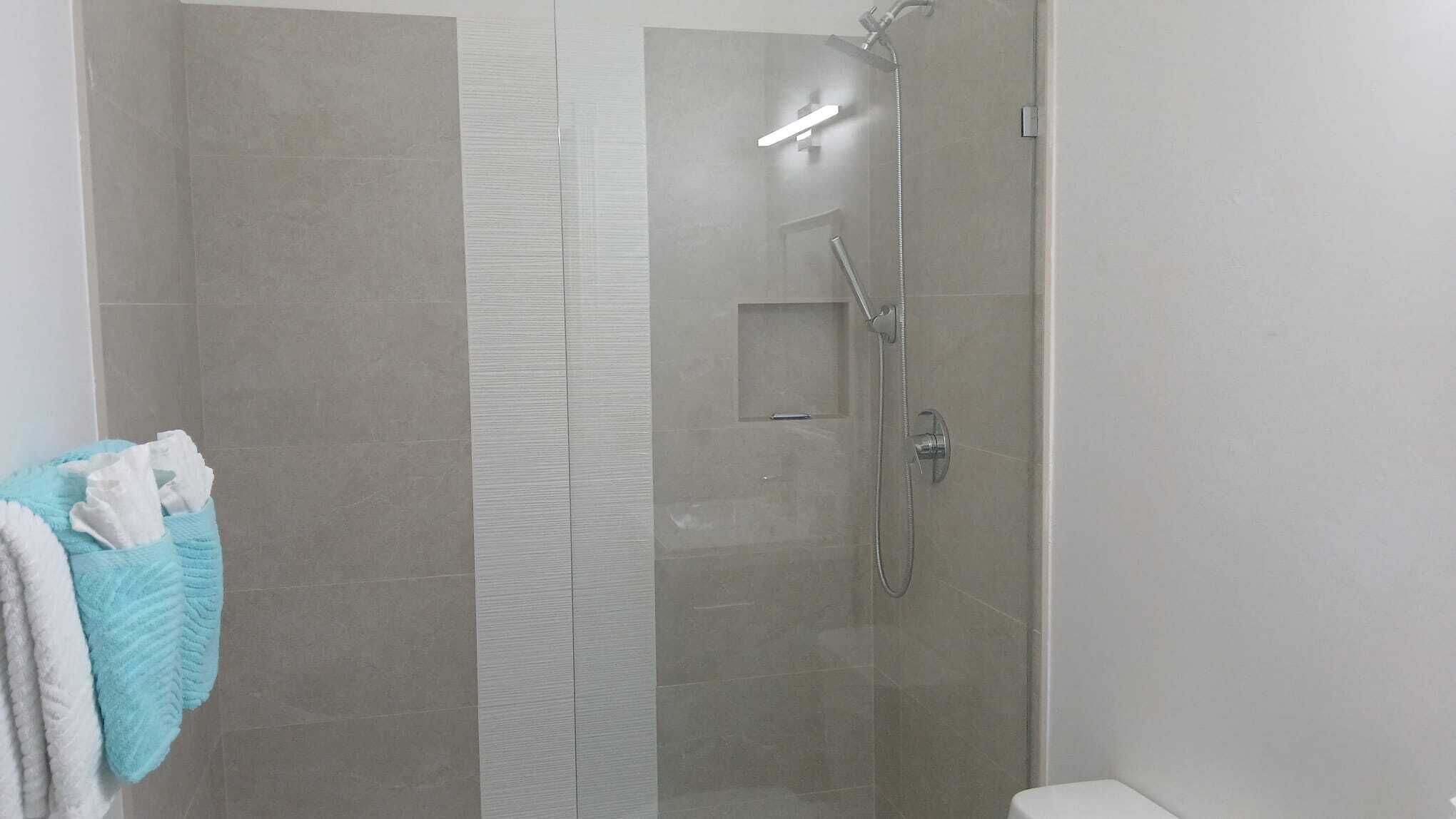 Een bad/douchecombinatie, een haardroger, handdoeken, zeep