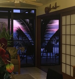 Enjoy the view from your balcony with a chair and table, featuring a ceiling fan and decorative wall piece.