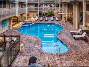 Relax by the central pool surrounded by lounge chairs and sun loungers on a spacious deck.