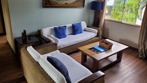 A living room with a sofa, a coffee table, and a painting on the wall. - Private Oceanview Bungalow #9 (Playa Hermosa)