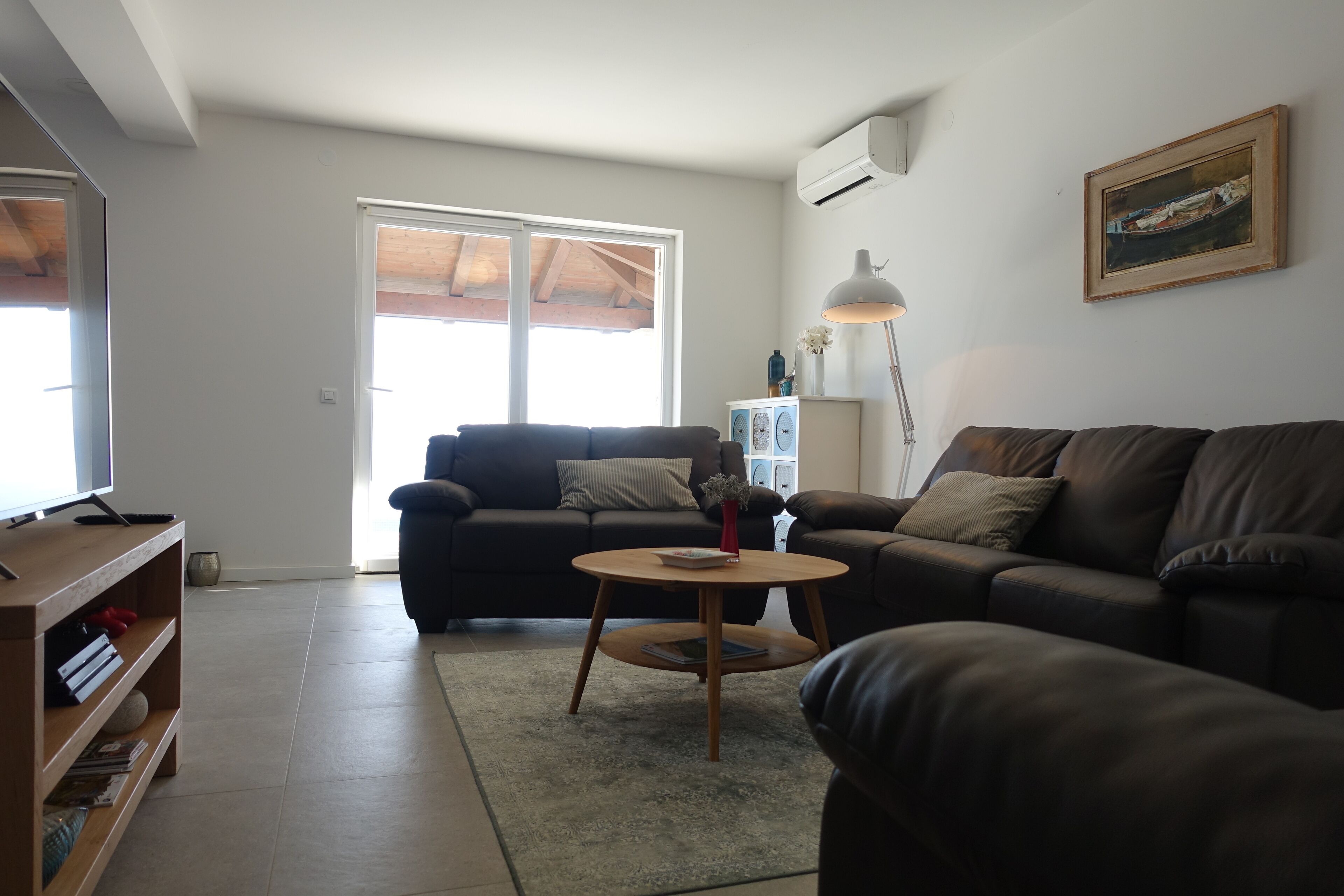 A living room with a sofa, a coffee table, and a TV stand.