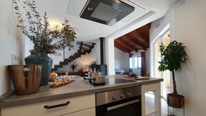 Een moderne keuken met een Bosch oven, een grote koperen pan en diverse verse groenten op het aanrecht.