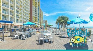 Guests can enjoy ocean views from the resort's boardwalk, featuring outdoor seating and dining areas.